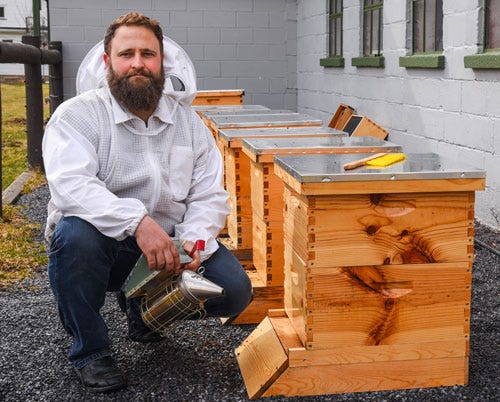 Rich Valley Apiary Seller next to beehive